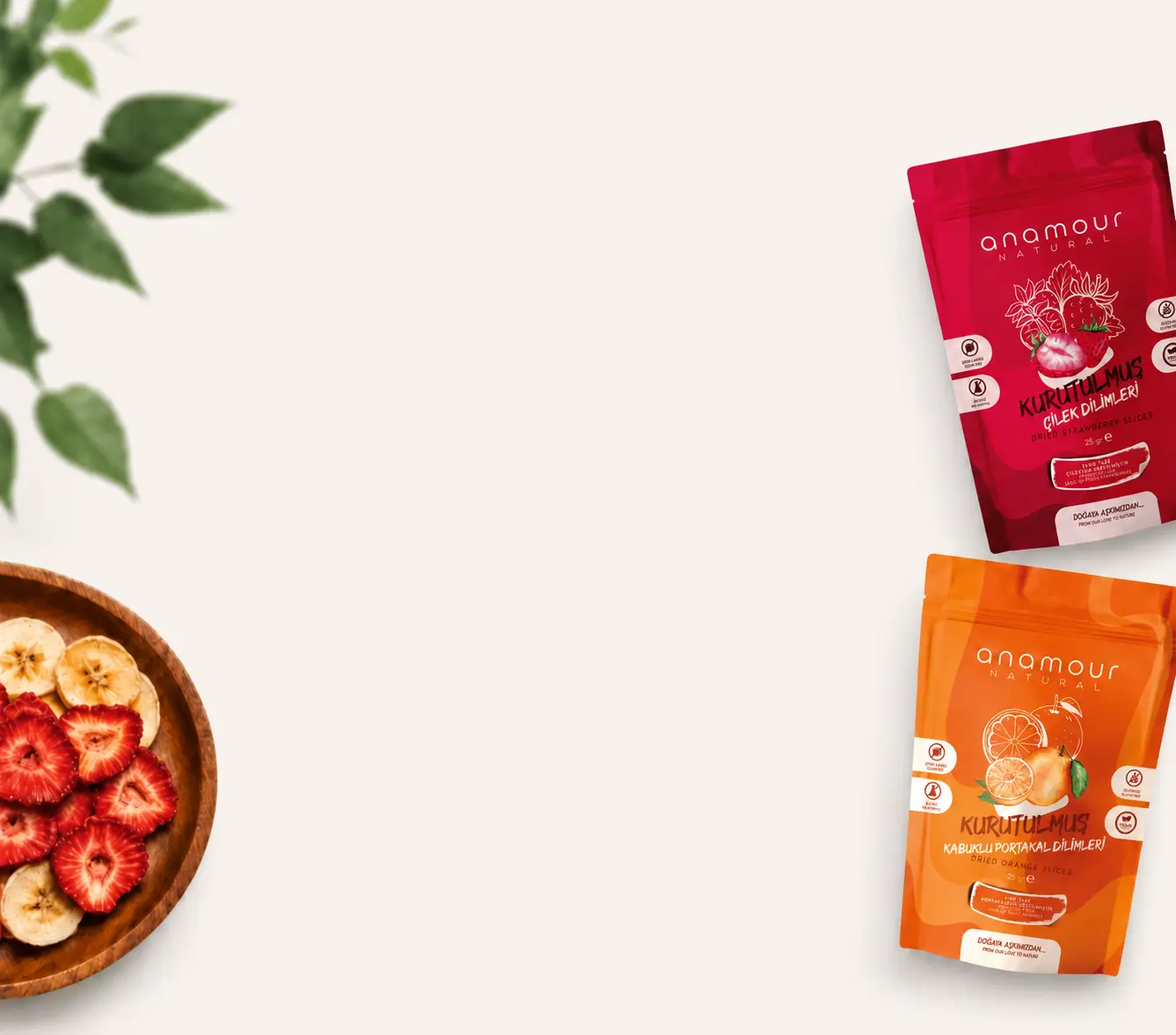 Anamour Natural kurutulmuş çilek ve portakal paketleri, doğal yapraklar ve ahşap kase ile düzenlenmiş ürün kompozisyonu